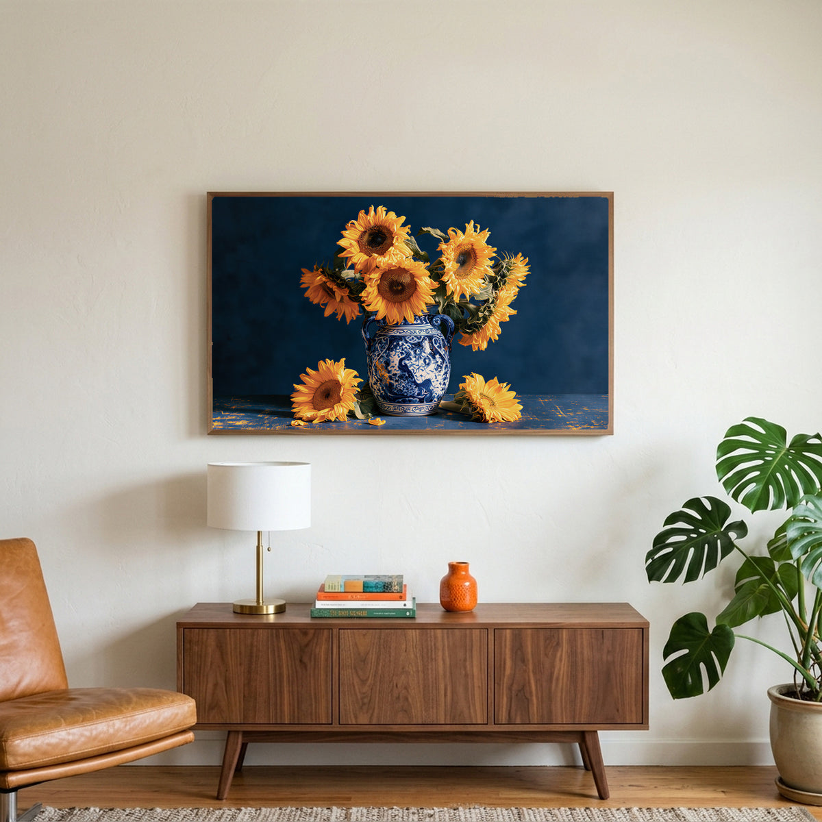 Sunflower still life art on a TV above a walnut credenza with a brass lamp and a monstera plant