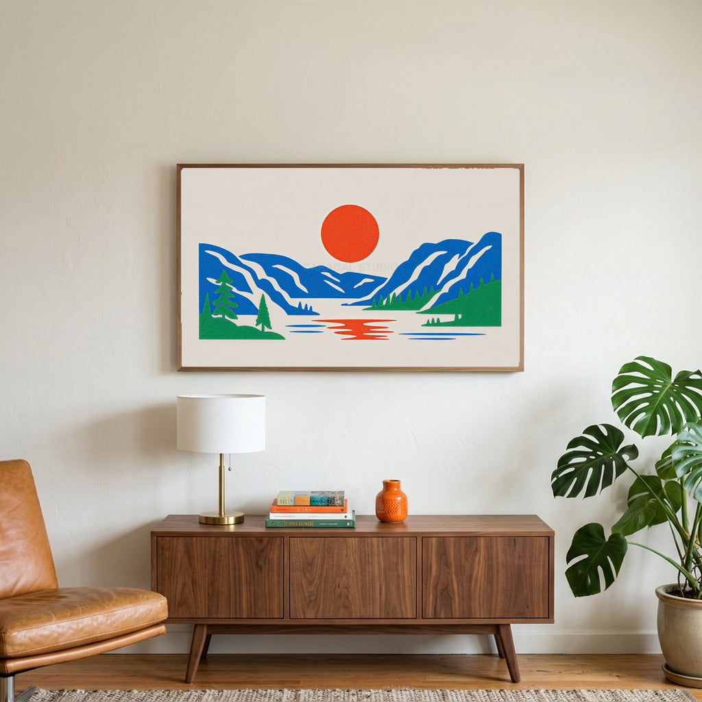 Mountain lake sun art on a TV above a walnut credenza with a brass lamp and a monstera plant
