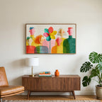 Faceless people and flower art on a TV above a walnut credenza with a brass lamp and a monstera plant