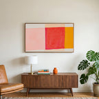 Abstract color blocks art on a TV above a walnut credenza with a brass lamp and a monstera plant
