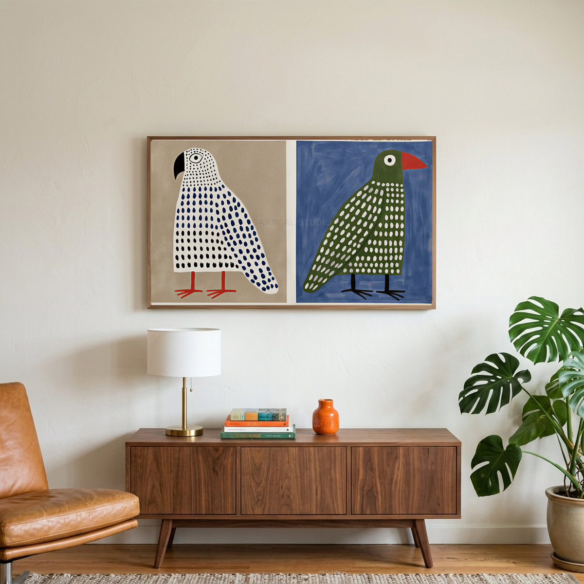 Polka dot birds art on a TV above a walnut credenza with a brass lamp and a monstera plant