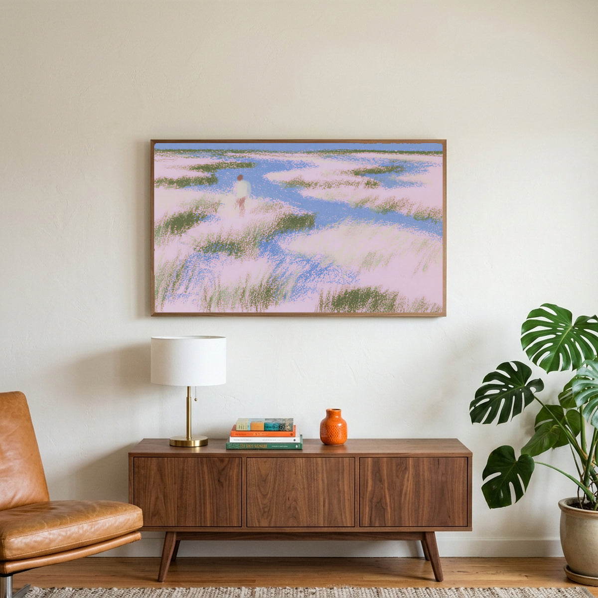 Pastel wetland walker art on a TV above a walnut credenza with a brass lamp and a monstera plant
