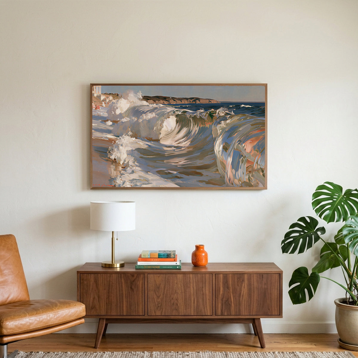 Crashing ocean waves art on a TV above a walnut credenza with a brass lamp and a monstera plant