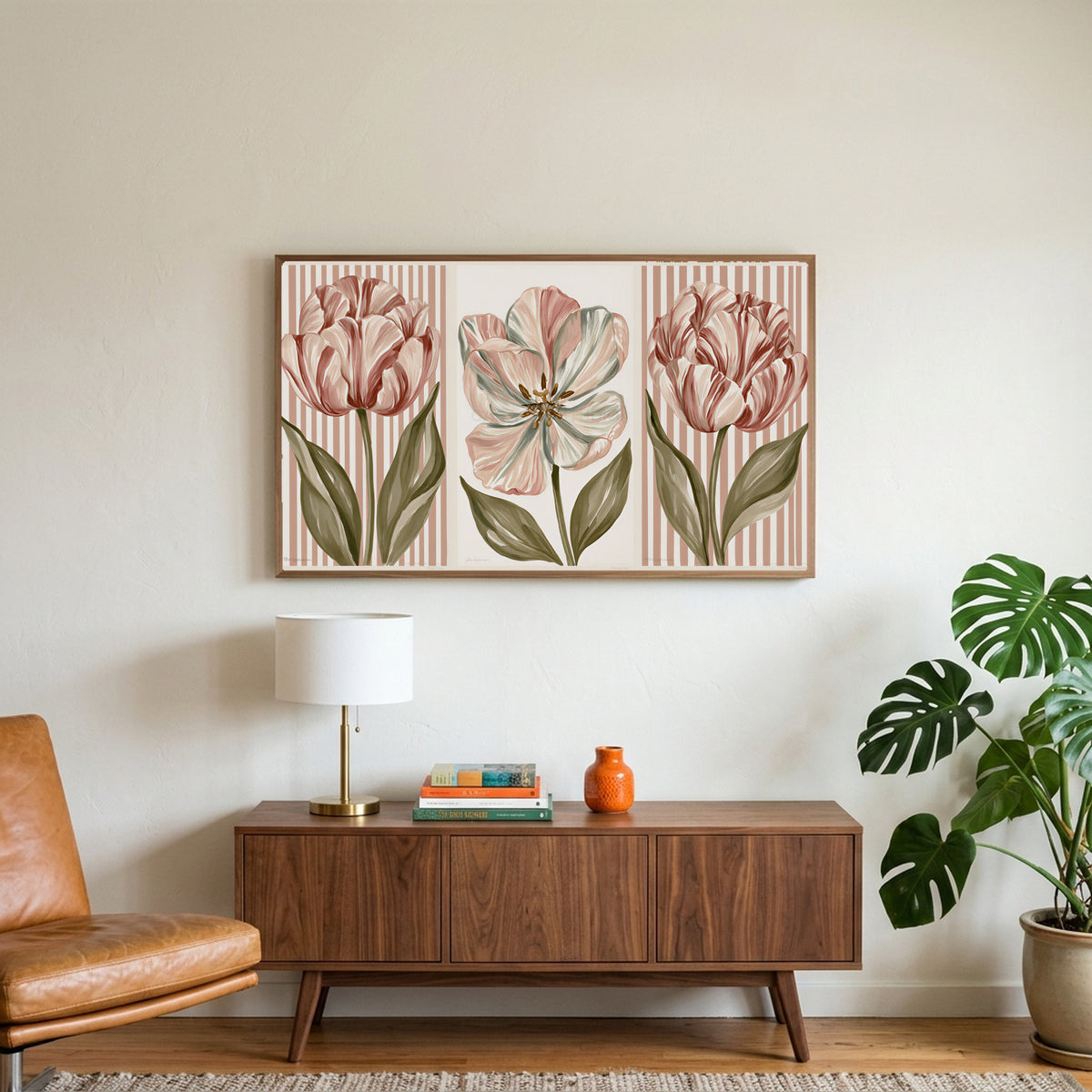 Tulip trio art on a TV above a walnut credenza with a brass lamp and a monstera plant