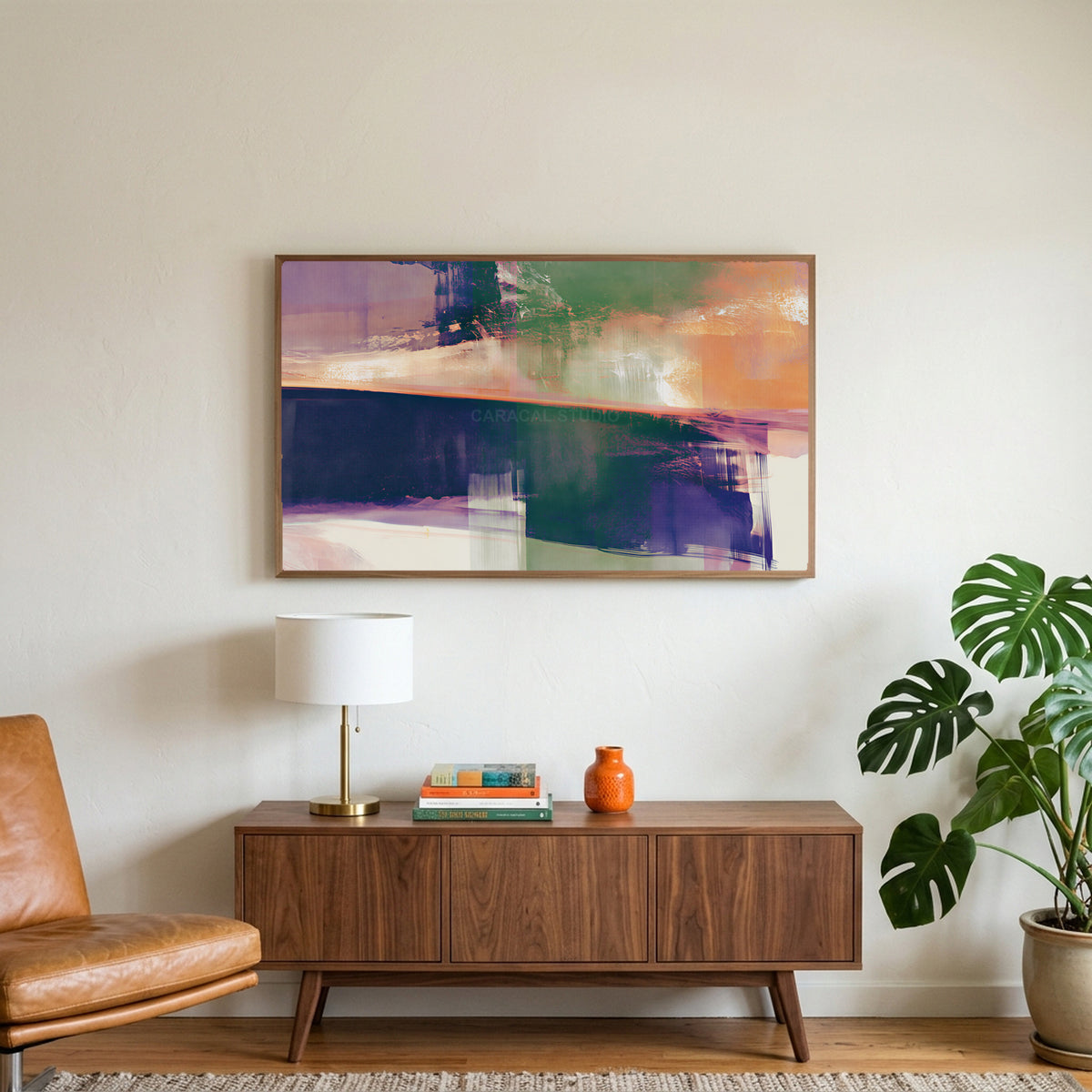 Abstract brushstroke art on a TV above a walnut credenza with a brass lamp and a monstera plant