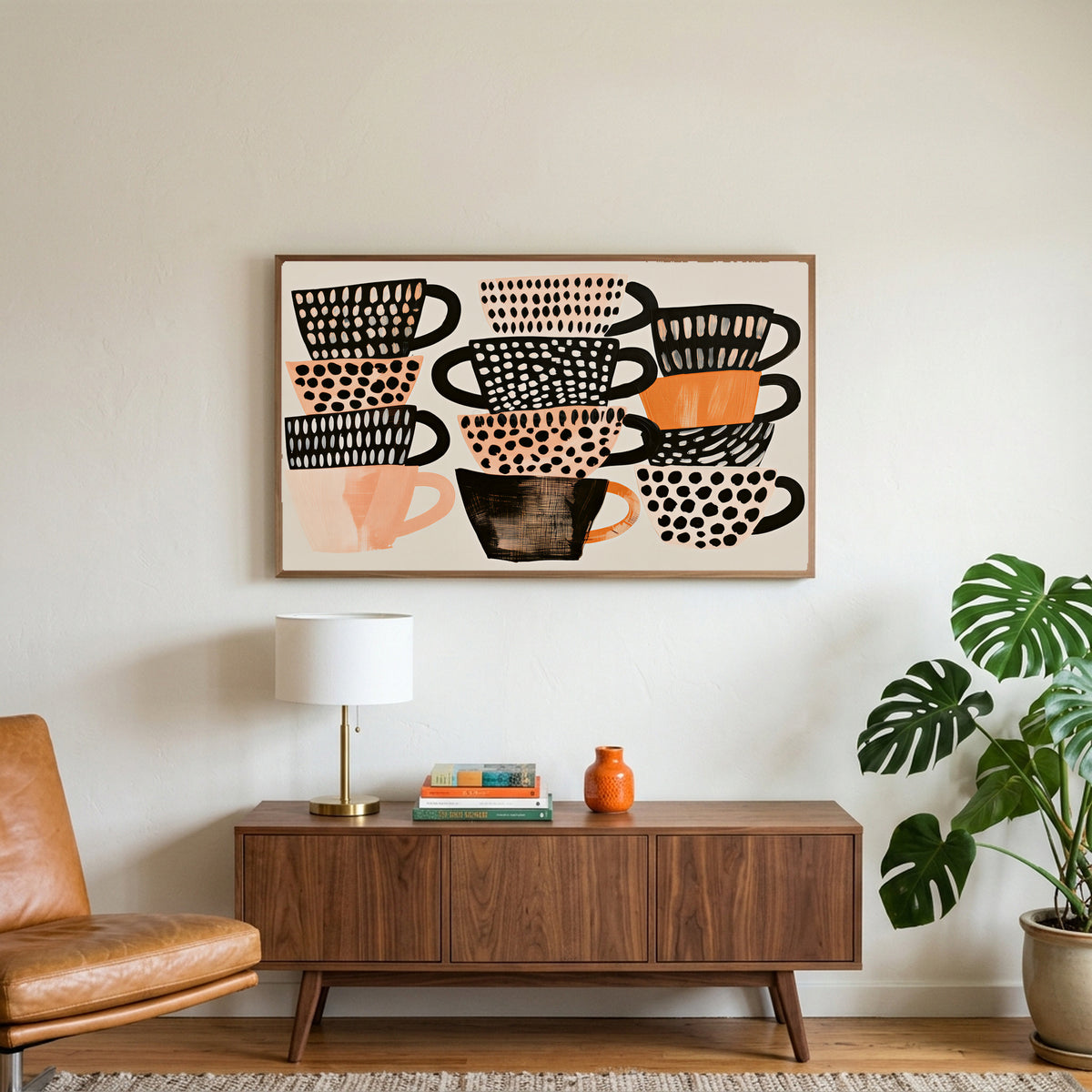 Stacked teacups art on a TV above a walnut credenza with a brass lamp and a monstera plant