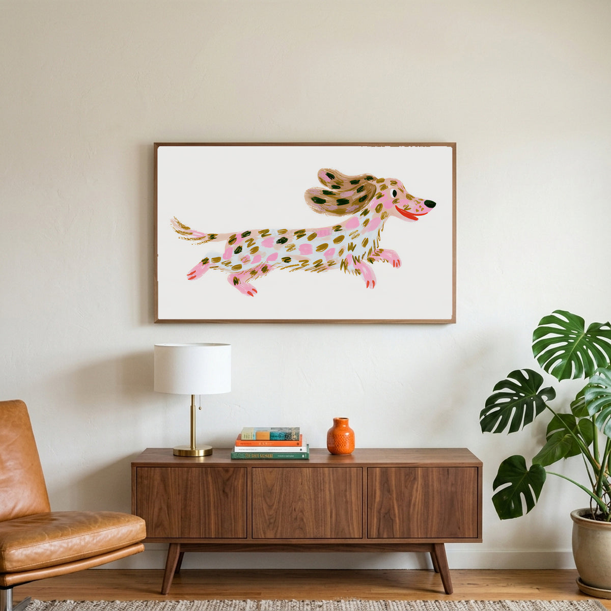 Running dachshund art on a TV above a walnut credenza with a brass lamp and a monstera plant