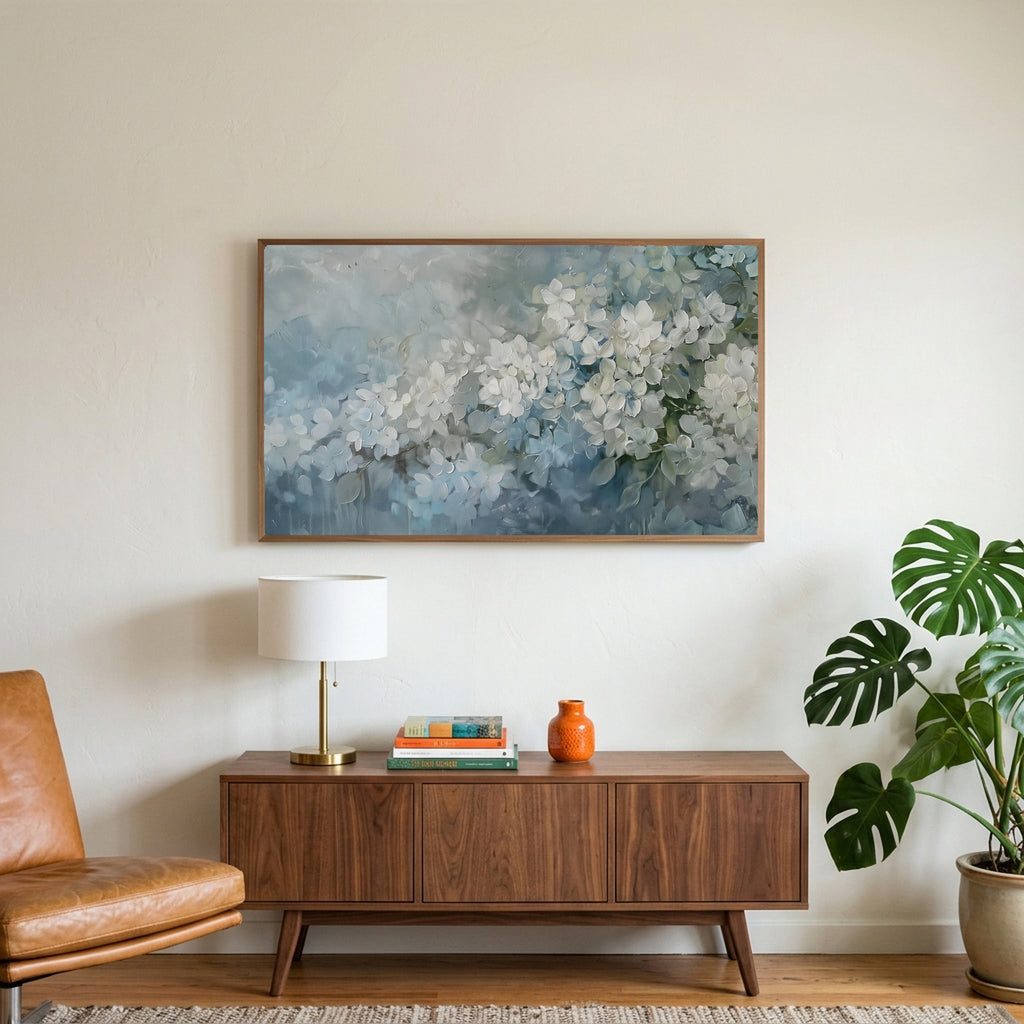 Hydrangea art on a TV above a walnut credenza with a brass lamp and a monstera plant