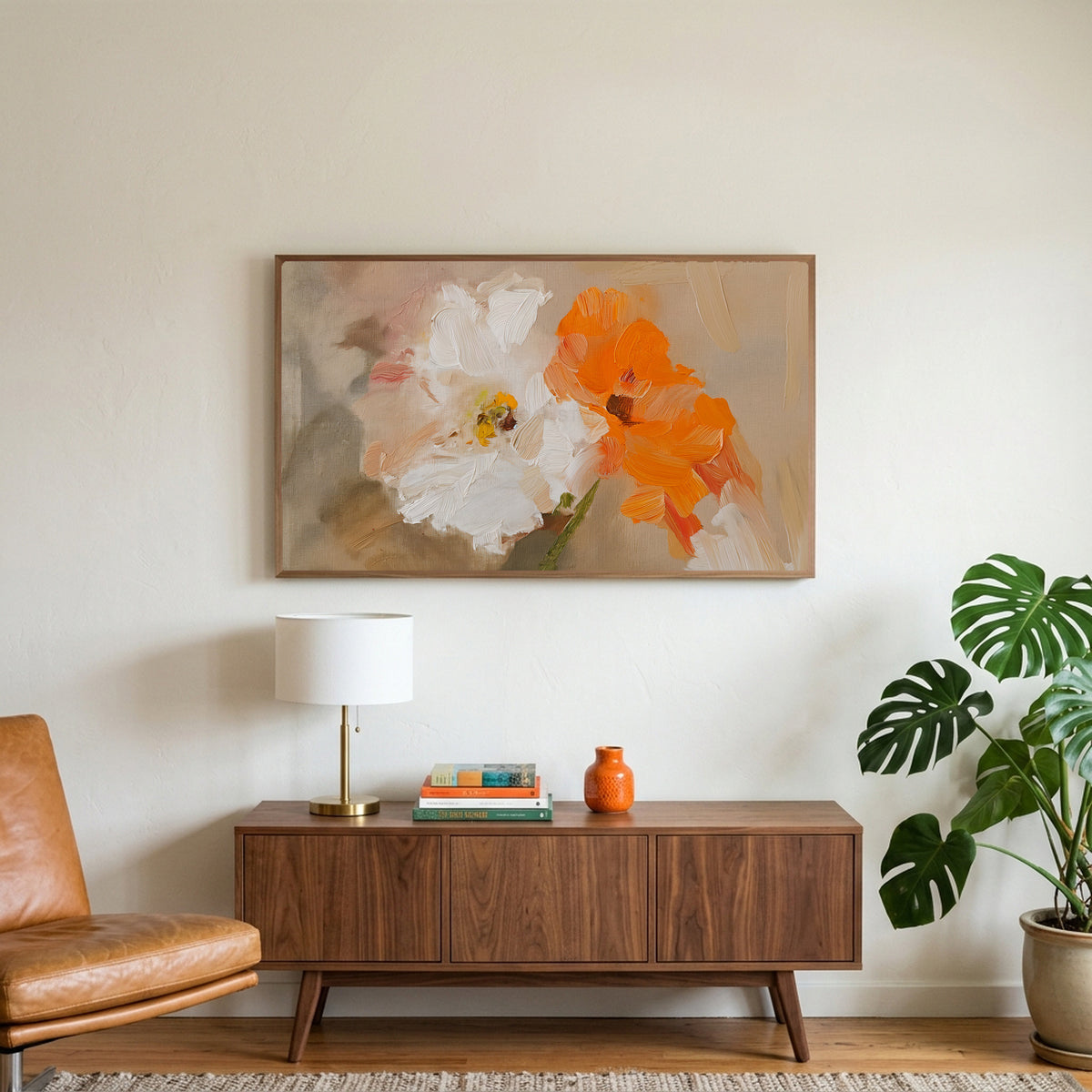 Poppy art on a TV above a walnut credenza with a brass lamp and a monstera plant