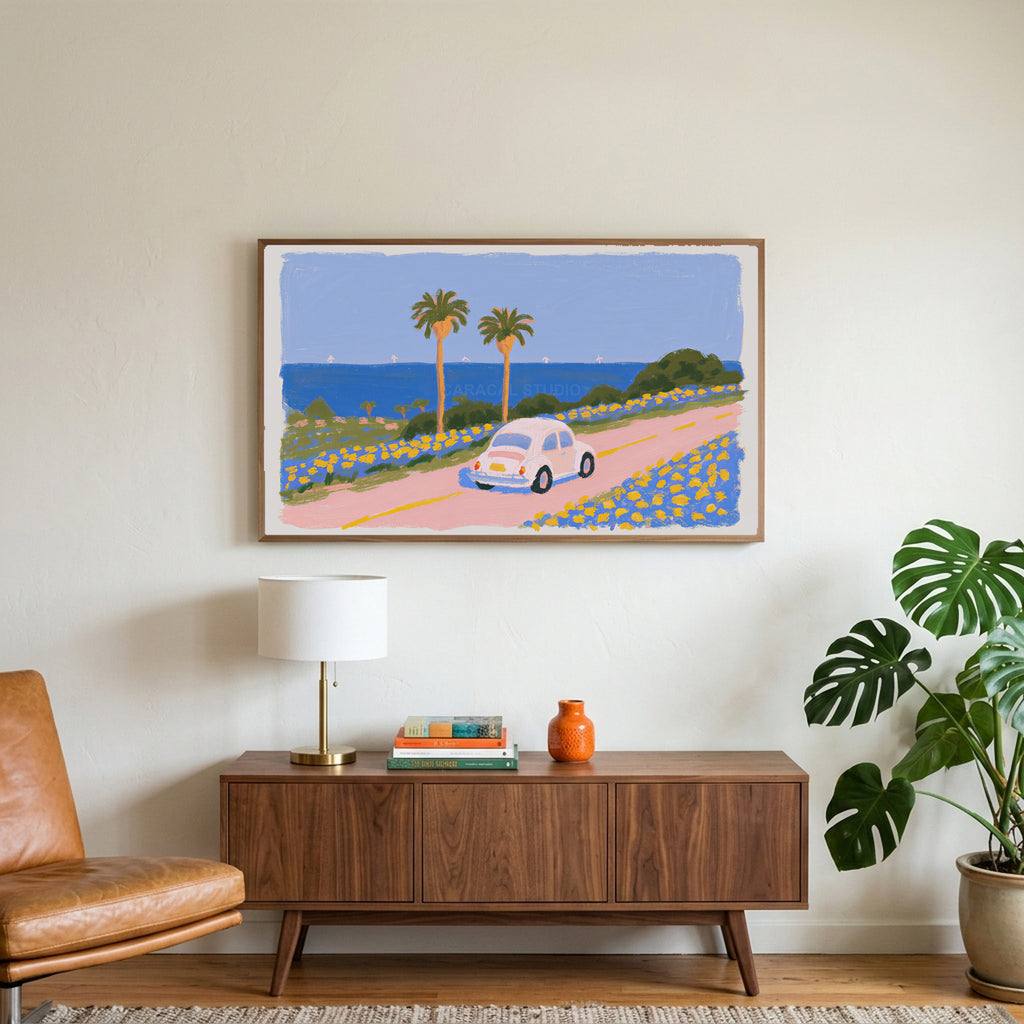 Seaside car art on a TV above a walnut credenza with a brass lamp and a monstera plant