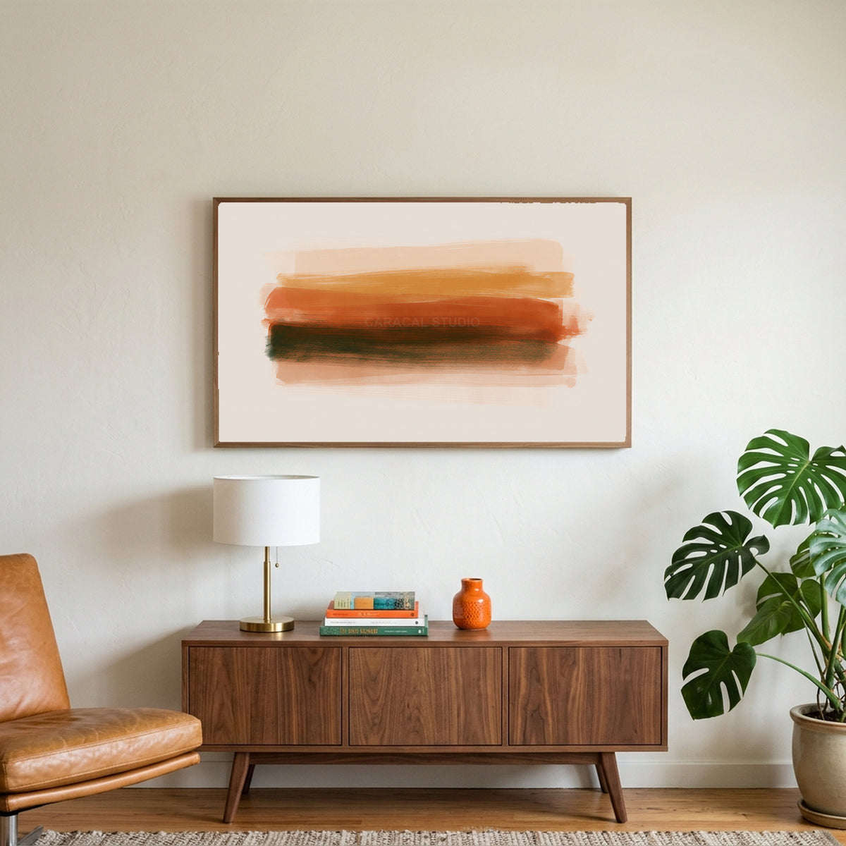 Terracotta brushstroke art on a TV above a walnut credenza with a brass lamp and a monstera plant