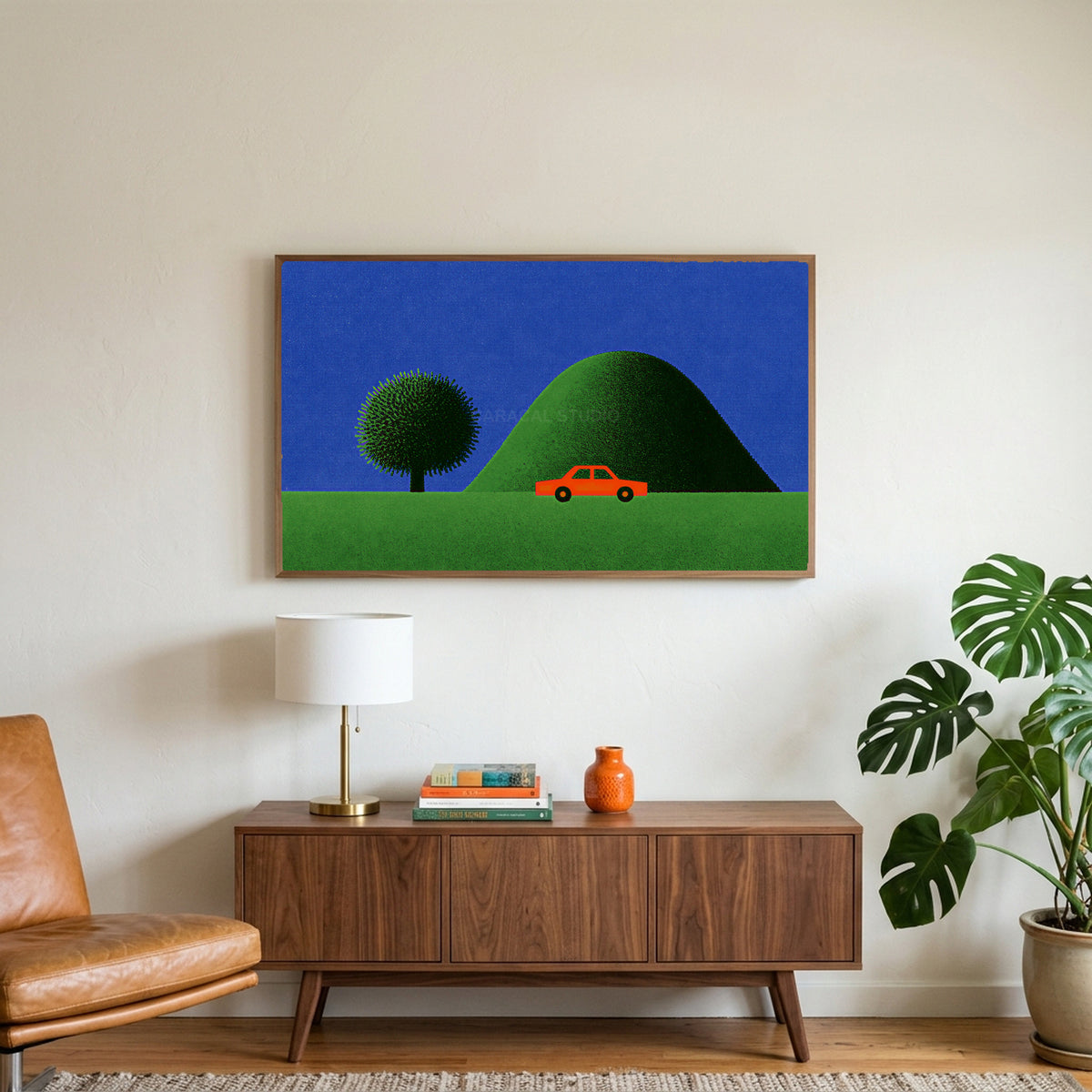 Red car by a green hill art on a TV above a walnut credenza with a brass lamp and a monstera plant
