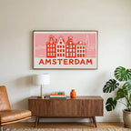 Amsterdam canal houses art on a TV above a walnut credenza with a brass lamp and a monstera plant
