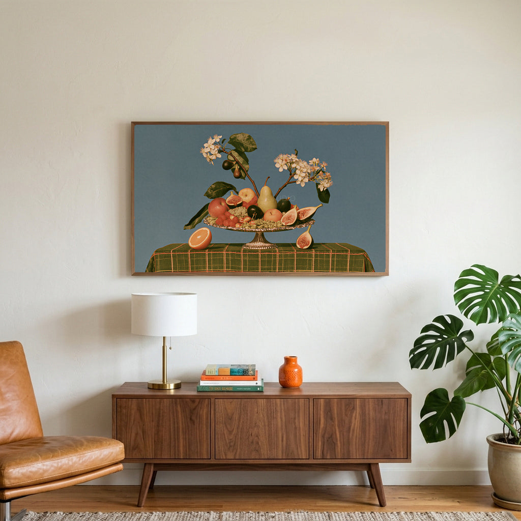 Fruit still life art on a TV above a walnut credenza with a brass lamp and a monstera plant