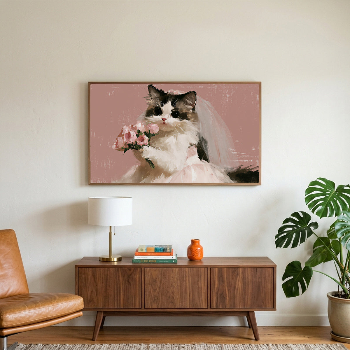 Cat bride art on a TV above a walnut credenza with a brass lamp and a monstera plant