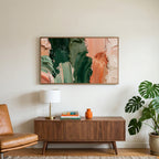 Green and copper strokes art on a TV above a walnut credenza with a brass lamp and a monstera plant