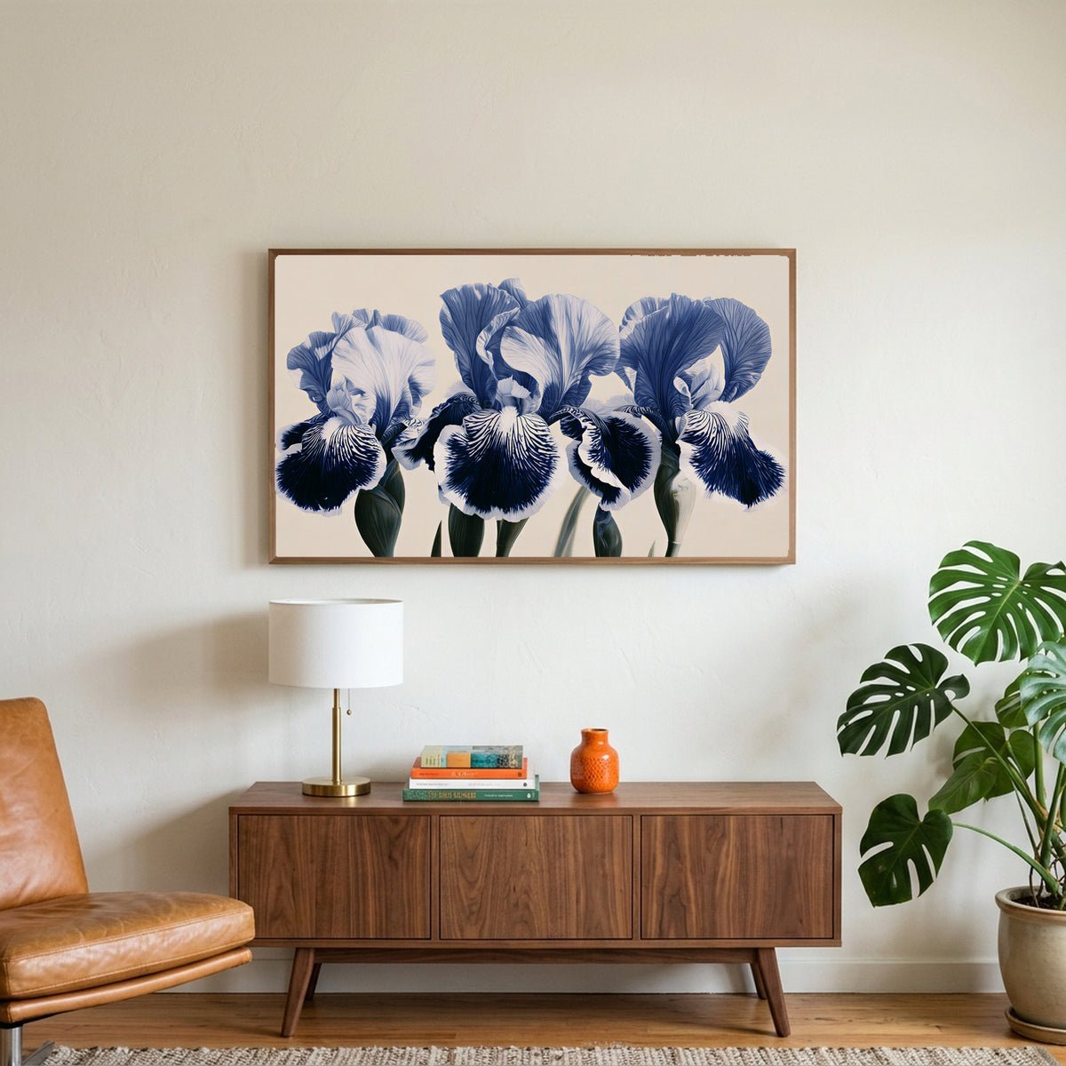 Blue iris art on a TV above a walnut credenza with a brass lamp and a monstera plant