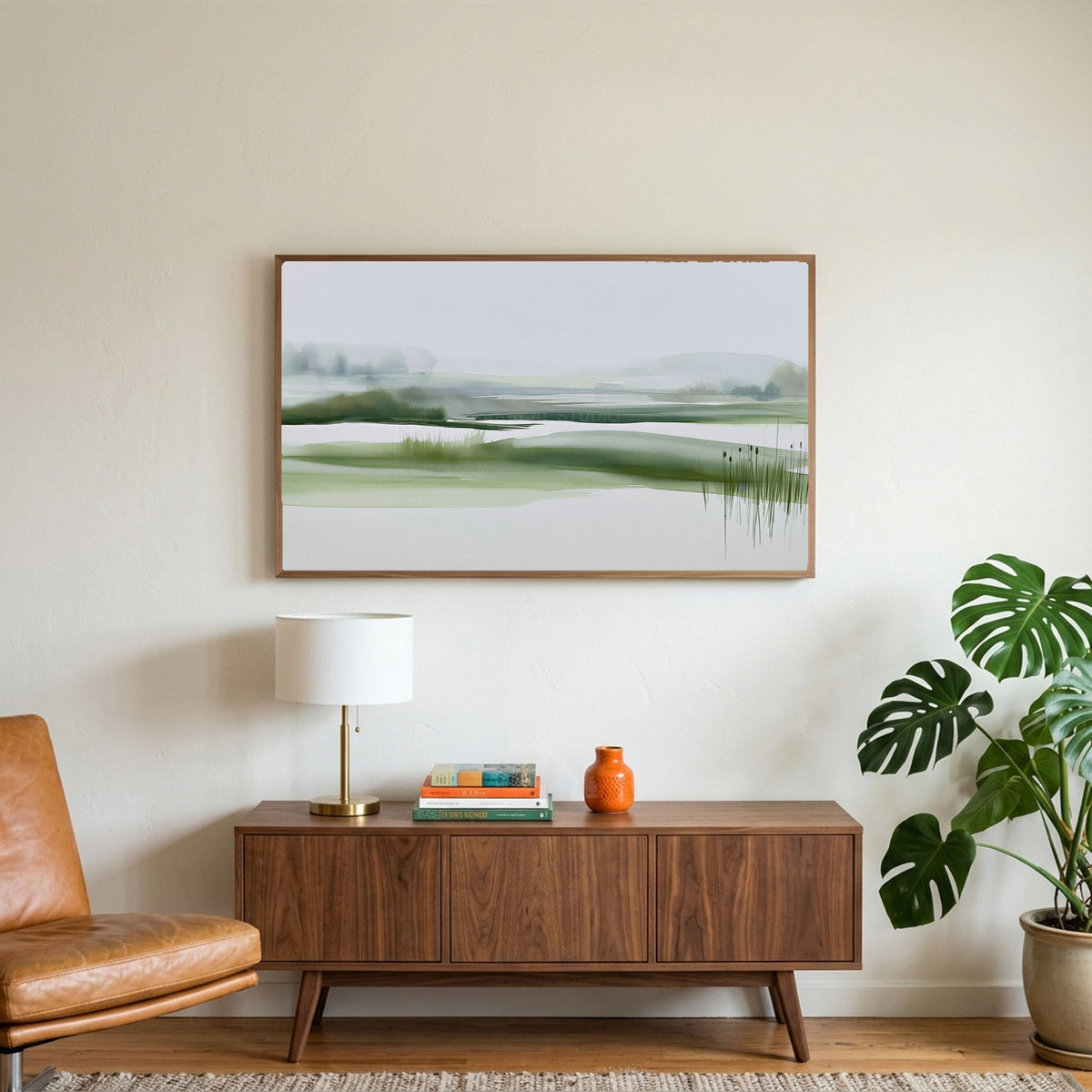 Misty wetland art on a TV above a walnut credenza with a brass lamp and a monstera plant