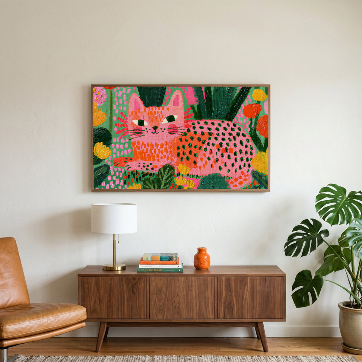 Spotted cat art on a TV above a walnut credenza with a brass lamp and a monstera plant