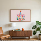 Rainbow birthday cake art on a TV above a walnut credenza with a brass lamp and a monstera plant