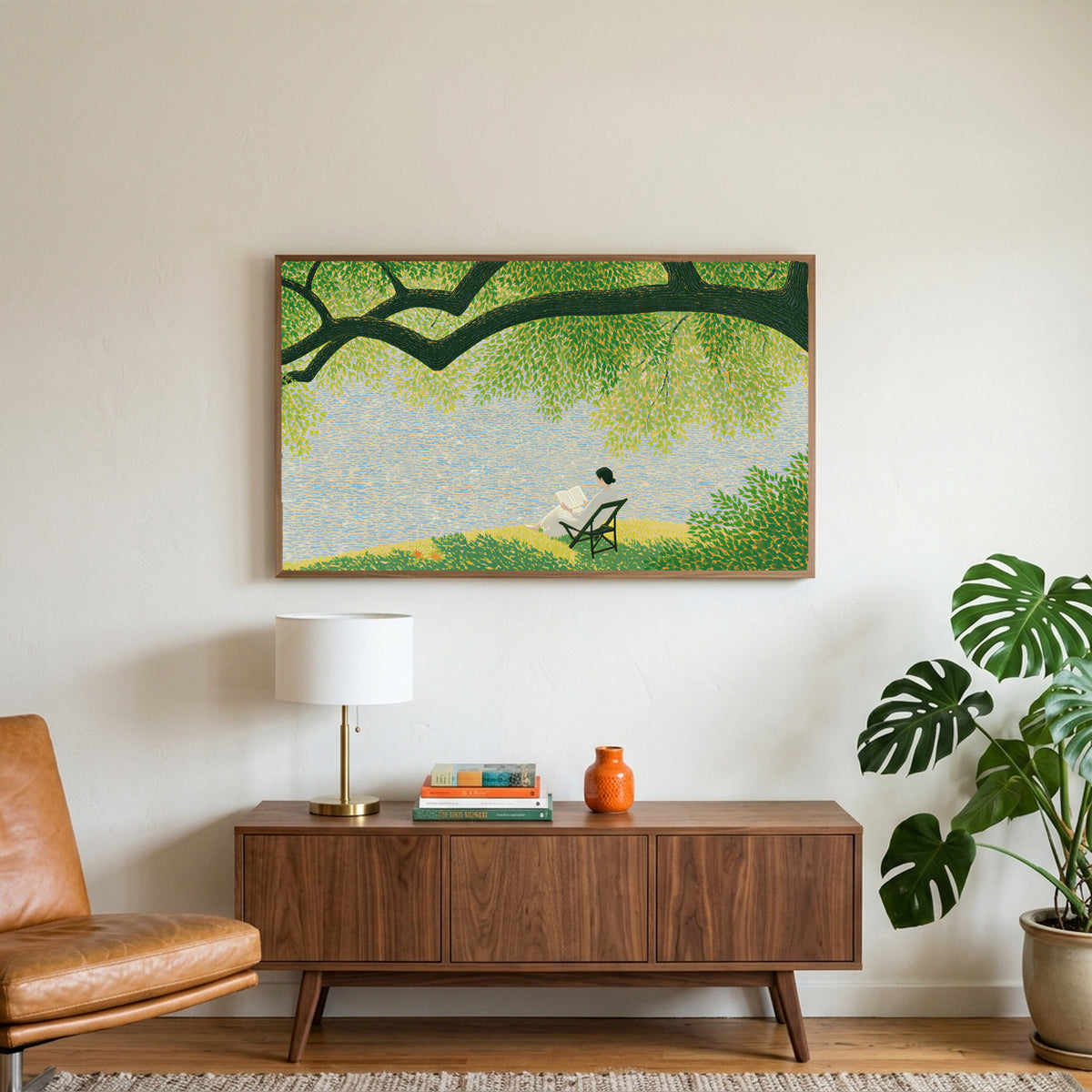 Lake and tree landscape art on a TV above a walnut credenza with a brass lamp and a monstera plant