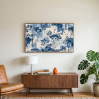 Blue botanical art on a TV above a walnut credenza with a brass lamp and a monstera plant