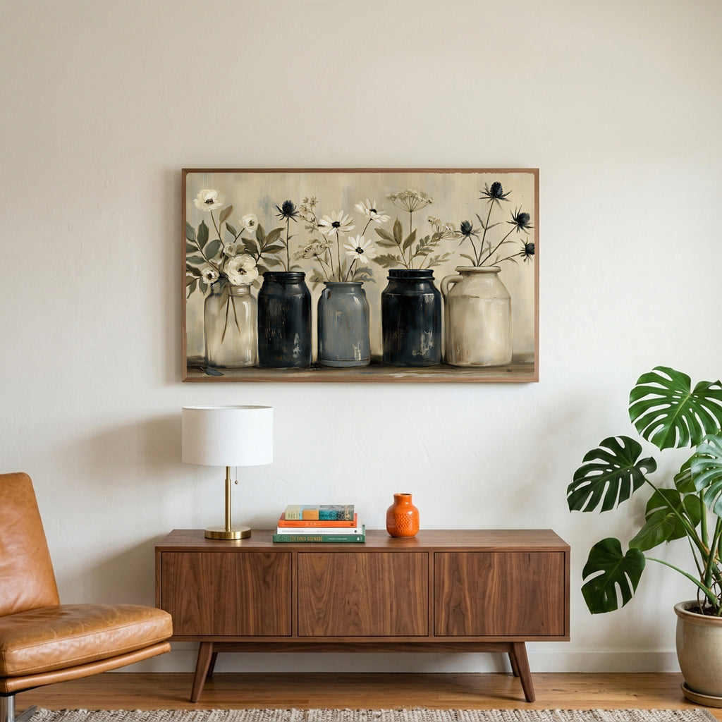 Farmhouse flower jars art on a TV above a walnut credenza with a brass lamp and a monstera plant