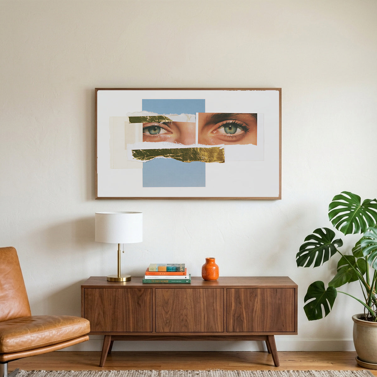 Eye collage art on a TV above a walnut credenza with a brass lamp and a monstera plant