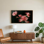 Ribbed glass flowers art on a TV above a walnut credenza with a brass lamp and a monstera plant