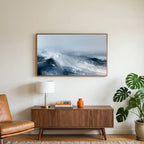 Ocean waves art on a TV above a walnut credenza with a brass lamp and a monstera plant